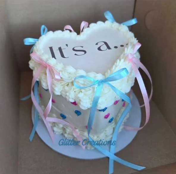 White heart cake with pink and blue ribbons
